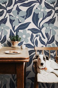 a dog sitting on a chair in front of a table