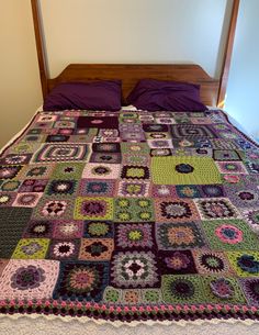 a bed with a purple blanket on top of it