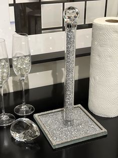 a black table with two wine glasses and a toilet paper dispenser