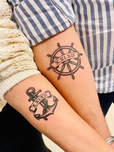 two people with matching tattoos on their arms, one has an anchor and the other has a ship wheel