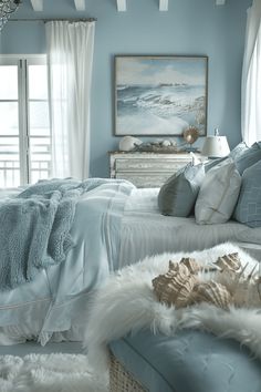 a bedroom with blue walls and white fur on the bed, along with an ottoman