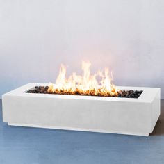 a white fire pit sitting on top of a blue floor next to a gray wall