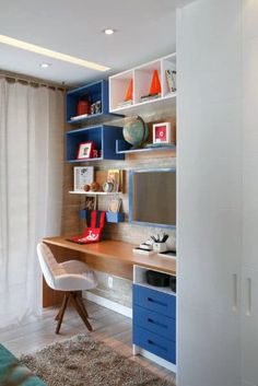 a blue and white desk in a room with shelves on the wall above it, along with a chair