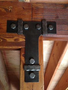 a close up of a wooden door hinge with metal latches and screws