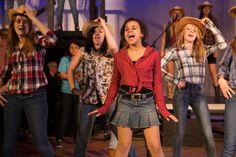 a group of young women standing on top of a stage