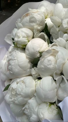 a bouquet of white peonies sitting on top of a table