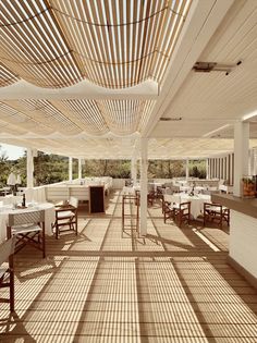 an outdoor dining area with white tables and chairs, wood slats on the ceiling