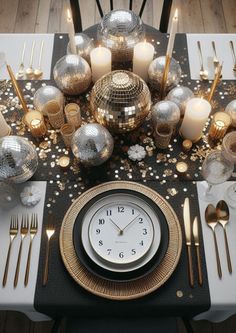 a table topped with a clock and lots of silver plates covered in gold confetti