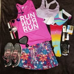 the contents of a running outfit are laid out on a black blanket with shoes, sunglasses and other items