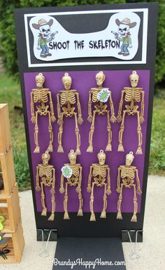 a display case with skeleton figurines on it in front of a purple background