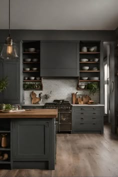 a kitchen with gray cabinets and wood floors, an island countertop and open shelving