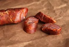 several pieces of meat sitting on top of brown paper