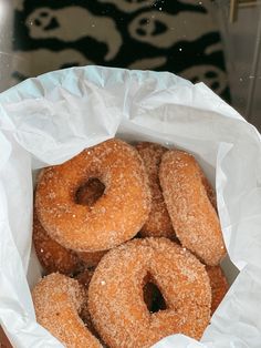 a basket filled with sugar covered donuts on top of a table