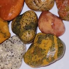 several different colored rocks on a white surface