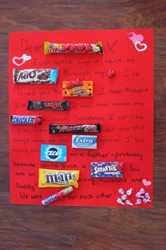 a candy bar valentine's card is displayed on a wooden table with red paper