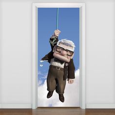 an open door with a cartoon character hanging from it's side and the sky in the background