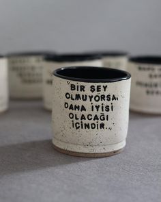 four black and white coffee mugs with writing on them