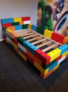 a bed made out of lego blocks in front of a wall with a poster on it