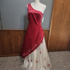 a red and white dress on display in front of a wooden paneled wall,