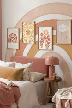 a pink and yellow bedroom with pictures on the wall above the headboard, bed in foreground