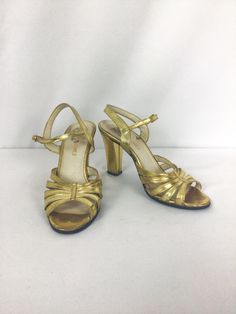 "Vintage 1990s gold lame leather strappy sandal Gold Lame high heel Leather sole Strap wraps around back ankle and buckles Toe box made up of 5 straps that \"gather\" in the center with a single strip of gold leather MEASUREMENTS: Marked US 6/EU 36.5/ Asia 22 Insole: 9.25\" Ball: 2 7/8\" Heel: 3 7/8\" Brand/Label: Carlos Sanchez Made in Italy Condition: Excellent * natural wear on sole and some light wear to gold lame on heels (See pic)" Vintage Gold Heels For Summer, Vintage Ankle Strap Sandals For Party, Retro Gold Open Toe Heels, Vintage Gold Open Toe Sandals, Retro Gold Heels For Party, Vintage Gold Sandals With Round Toe, Vintage Gold Ankle Strap Heels, Gold Vintage Sandals With Round Toe, Vintage Gold Sandals For Evening