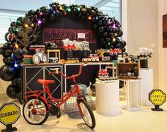 a bike is parked in front of a display with balloons and other items on it