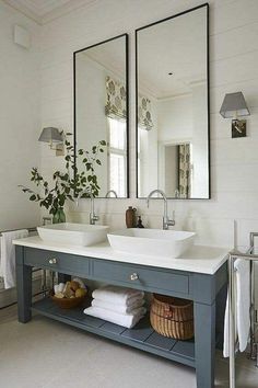 a bathroom with two sinks and mirrors on the wall