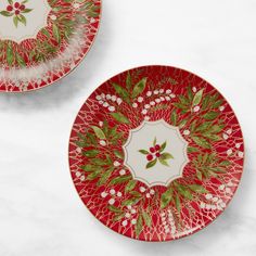 two red and green plates with holly designs on them