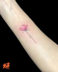 a small pink flower tattoo on the left forearm and wrist with words love written in cursive font