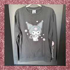 It’s Sweater Weather And This Is The Softest Long Sleeve Sweatshirt And One Of The Cutest. Kuromi Is Printed On The Front Of This Black Sweatshirt And Her Name Is On One Sleeve. If You Love The Sweet Yet Mischievous Kuromi This Brand New Sweatshirt Is Perfect For You. Size M Length 27” Width 22” 60% Cotton And 40% Polyester Machine Washable And Tumble Dry Low Official Licensed Sanrio Item Kawaii Long Sleeve Tops For Fall, Cute Long Sleeve Tops For Streetwear, Pink Long Sleeve Sweater With Graphic Print, Pink Kawaii Long Sleeve Sweatshirt, Pink Long Sleeve Kawaii Sweatshirt, Pink Long Sleeve Kawaii Top, Cute Black Long Sleeve Tops, Fall Kawaii Style Cotton Top, Cute Gray Crew Neck Top