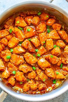 a pot filled with chicken and sauce on top of a table