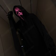 a person in a dark room with a pink mask on their face and hands behind them