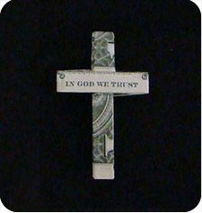 a cross with the words in god we trust written on it and money wrapped around it