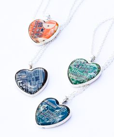 three heart shaped pendants with circuit board printed on them, hanging from a silver chain