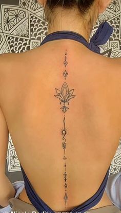 the back of a woman's neck with a flower tattoo on it