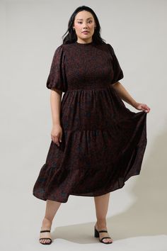 The Kalida Beau Frazier Smocked Tiered Midi Dress is reminding us of all the reasons to feel gratitude. Full, short puff sleeves frame a flattering smocked bodice that tops a flowy, tiered midi skirt. A keyhole sits at the top of the back to make getting in and out easier. Wear it to any event with your favorite accessories and boots to complement the look.- Smocked- Keyhole- Tiered- Bubble sleeves- Color: ChocolateSize + Fit - Model is 5'9" and wearing size 2X- Measurements taken from size 2X - Modest Smocked Ruched Short Sleeve Dress, Billowy Smocked Dress With Short Sleeves, Fall Smocked Dress With Short Sleeves, Flowy Smocked Dress With Short Elastic Sleeves, Brown Dress With Smocked Bodice And Short Sleeves, Brown Short Sleeve Dress With Smocked Bodice, Brown Smocked Bodice Dress, Midi Length, Flowy Brown Smocked Dress With Smocked Bodice, Brown Smocked Midi Dress