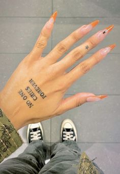 a person's hand with an orange manicure and the words together on it