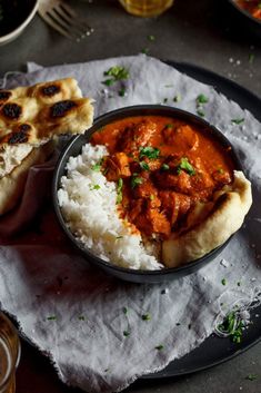 some food is sitting on a plate with rice and sauce in it, along with other dishes