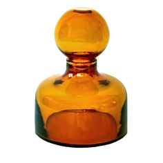 an orange glass vase sitting on top of a table