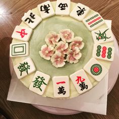 a cake decorated with flowers and chinese characters on it's side, sitting on top of a table