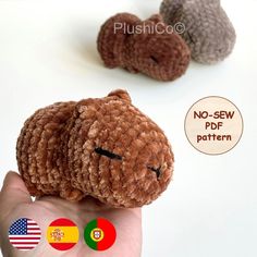 there is a small stuffed animal in the palm of someone's hand, with two flags behind it