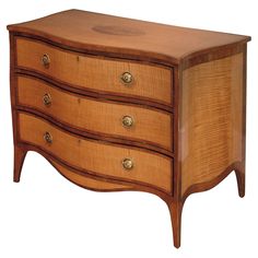 a wooden dresser with three drawers and gold knobs