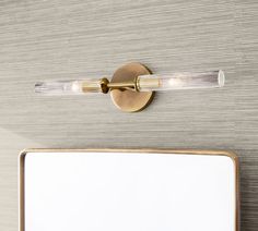 a close up of a bathroom mirror with a light on the wall next to it