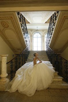 a woman in a wedding dress sitting on some stairs