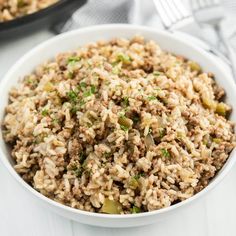 a white bowl filled with rice and meat