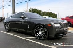 a black rolls royce parked in a parking lot