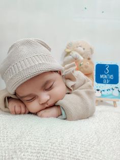 a baby laying on top of a white blanket