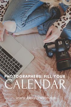 a woman is sitting on her bed with a laptop and camera