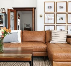 a living room filled with lots of furniture and pictures on the wall above it's coffee table