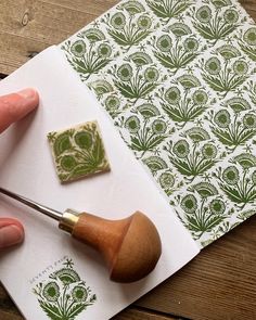 a person is using a stamper to make a flower pattern on a piece of paper